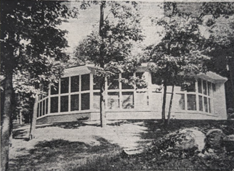 Black and white photo of round building with rows of large windows.