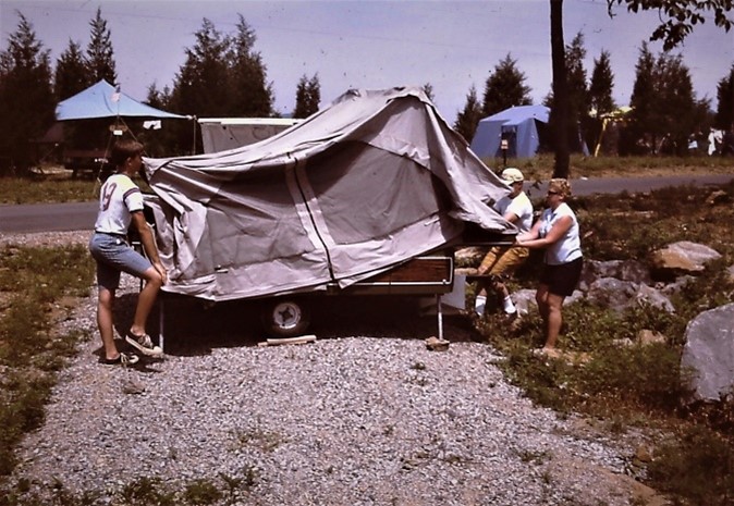 Three people assemble a pop-up tent.