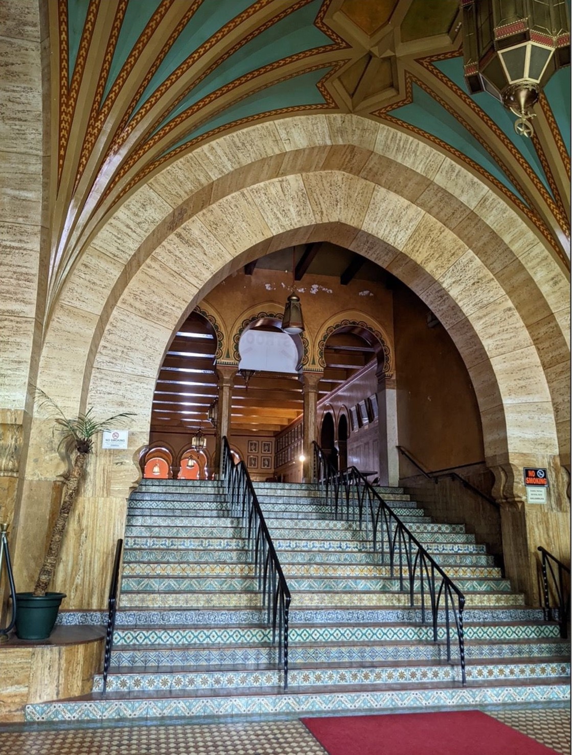 Large arched opening at top of tiled stair inside a building.