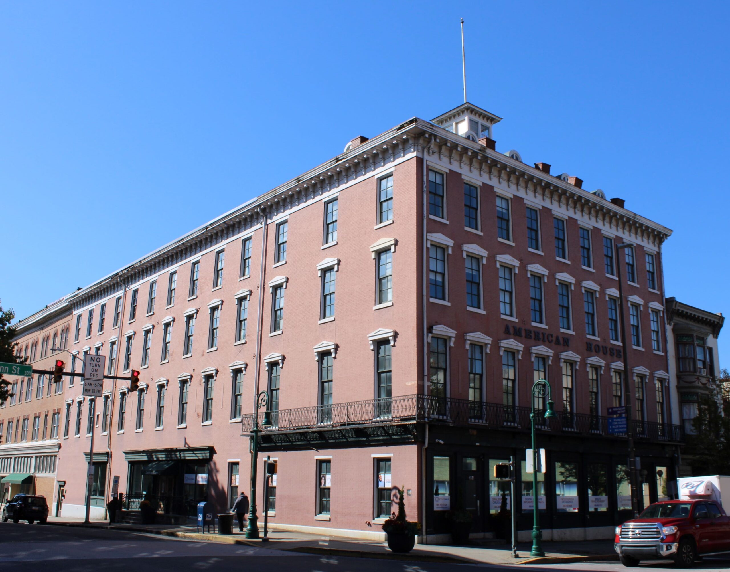 Four story brick building in an urban area with large windows on each floor.