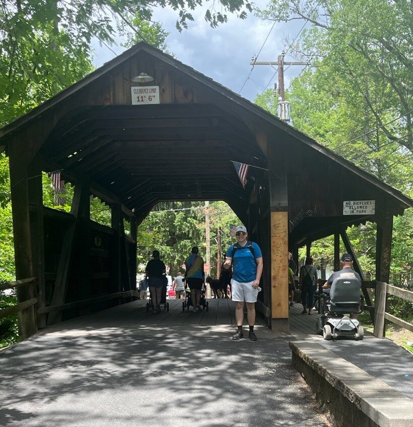 People walking through a covered bridge.