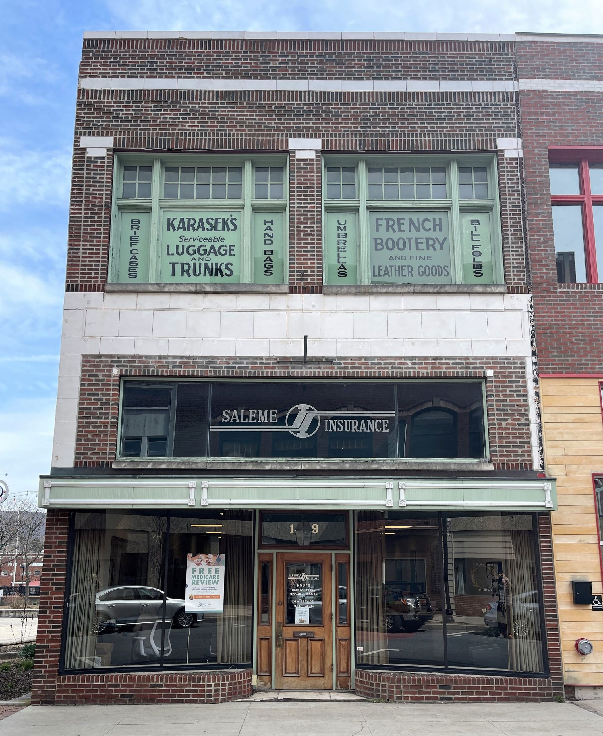 Three-story brick commercial building with storefront windows on the first floor.