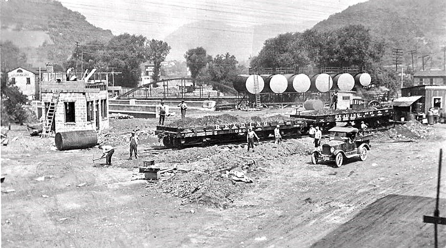 Black and white photograph of people building a bridge.