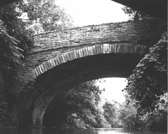 Tall stone bridge over water.