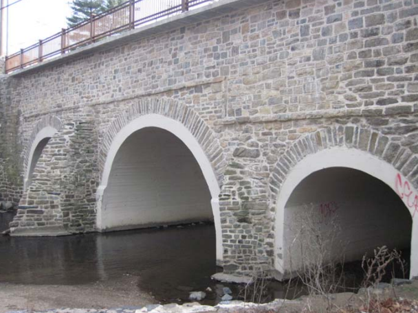 Stone arches over a shallow stream.