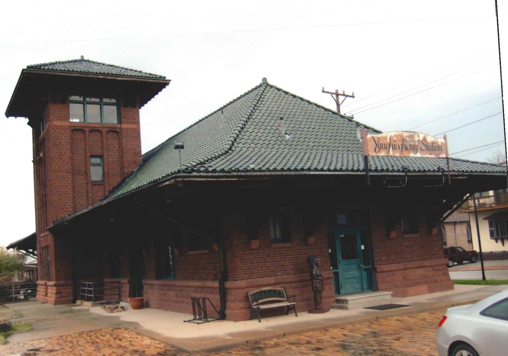 One story brick building with steep roof and large tower.