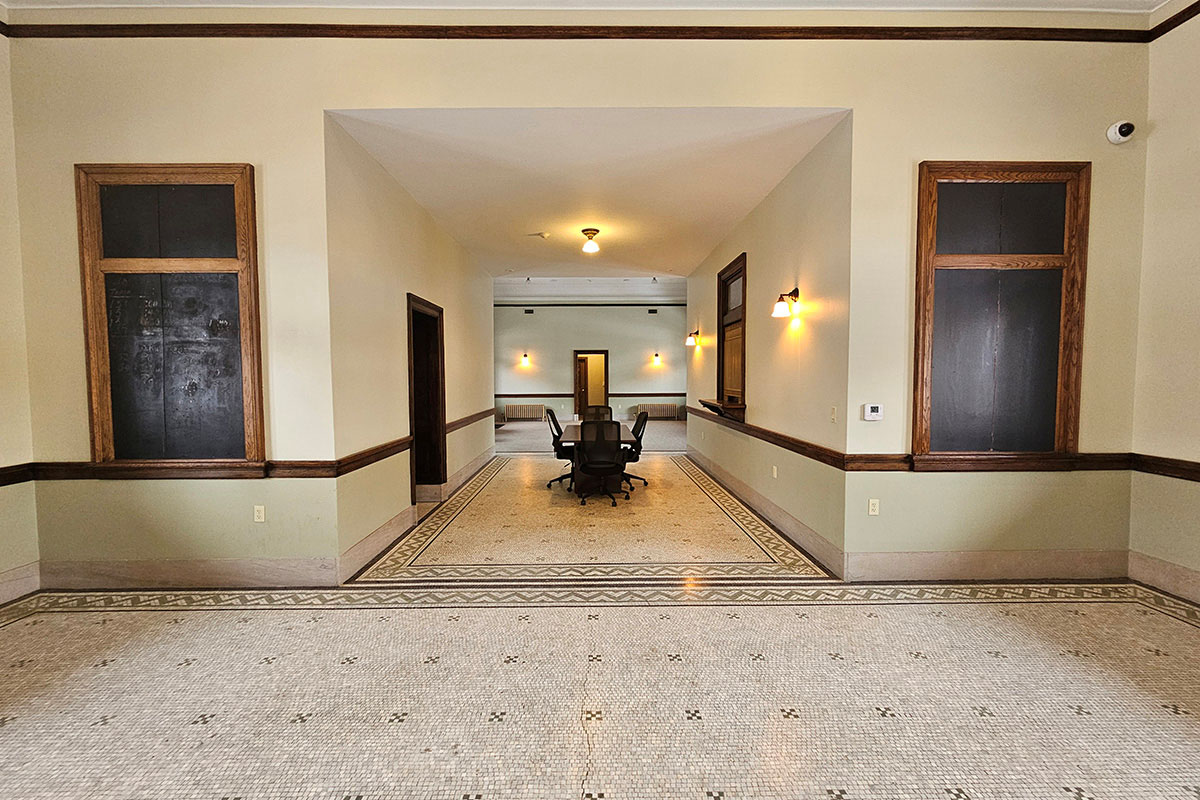 Vacant room with table and chairs in center.