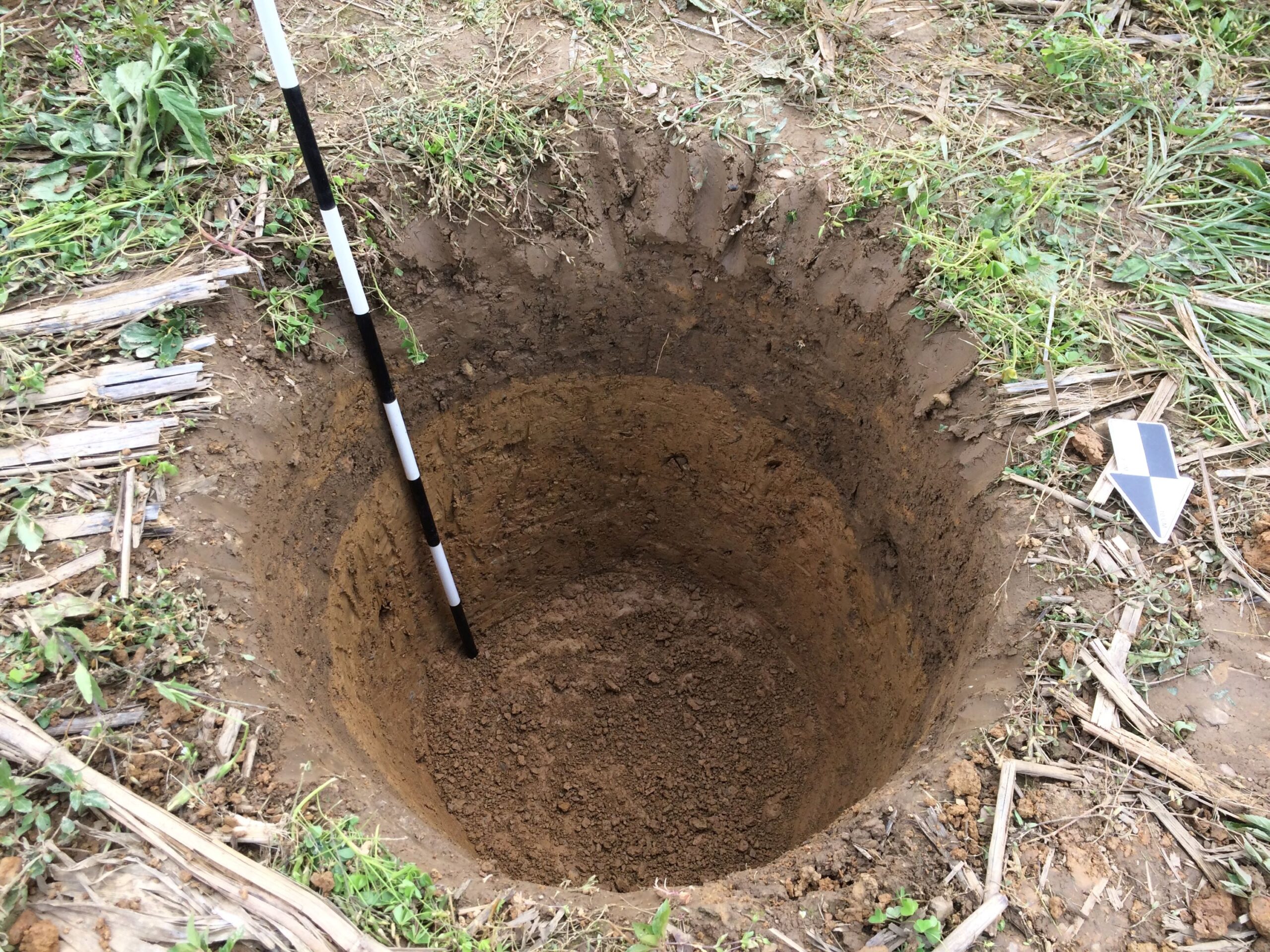 Cylindrical hole dug into soil.