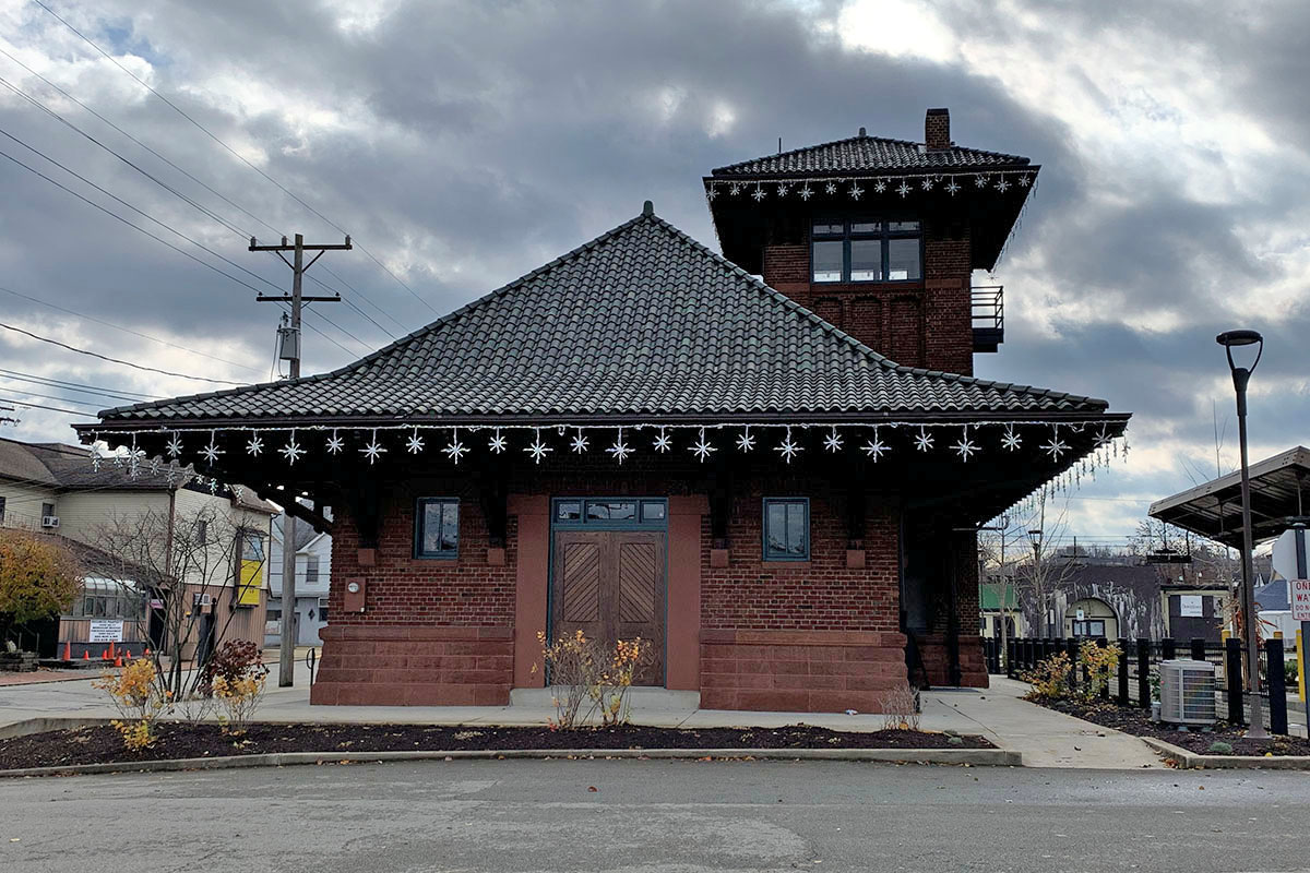 One story brick building with steep roof and large tower.