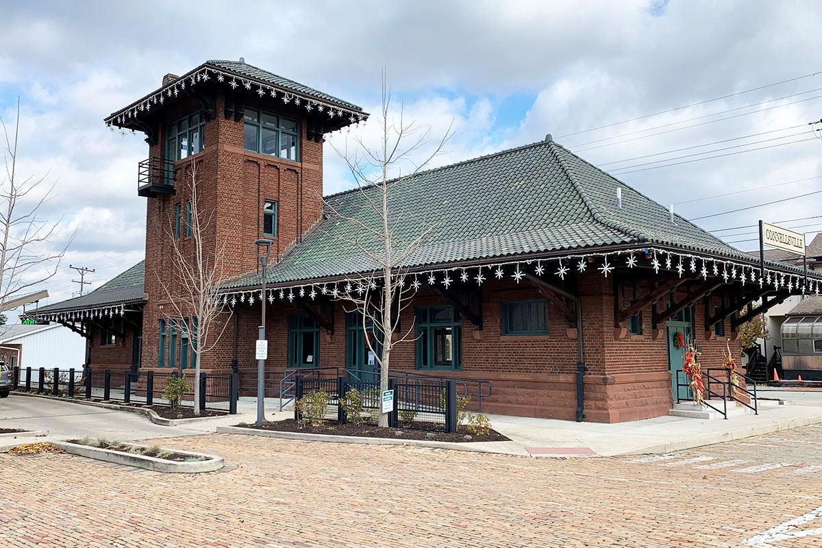 One story brick building with steep roof and large tower.