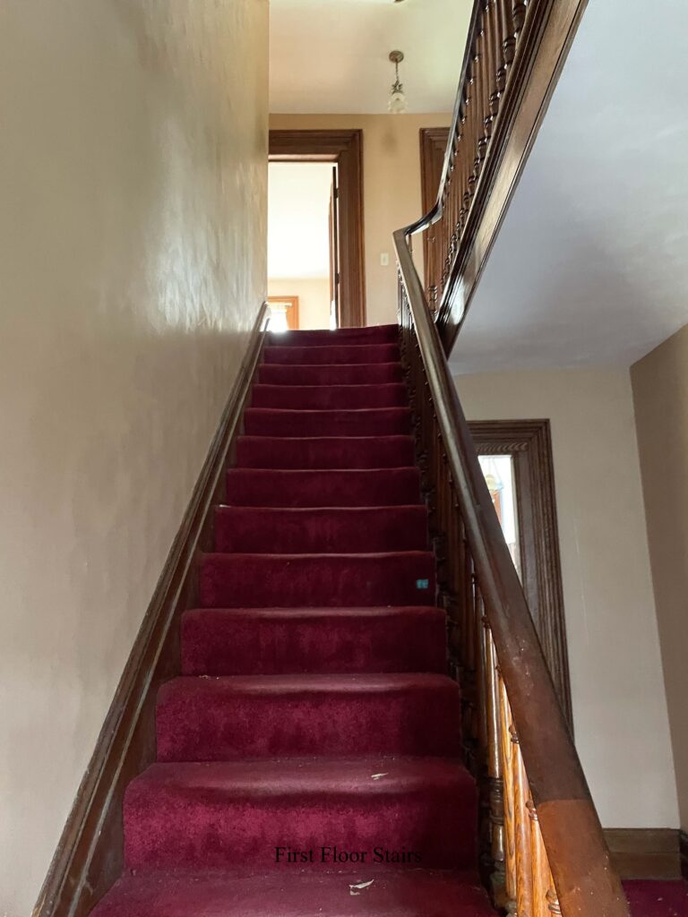 Carpeted staircase with open doors visible at top.