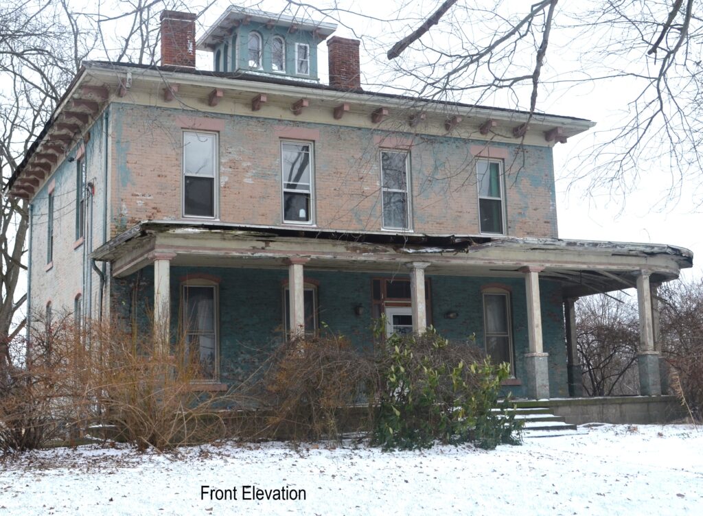 Two-story brick building with open one-story porch and many windows.