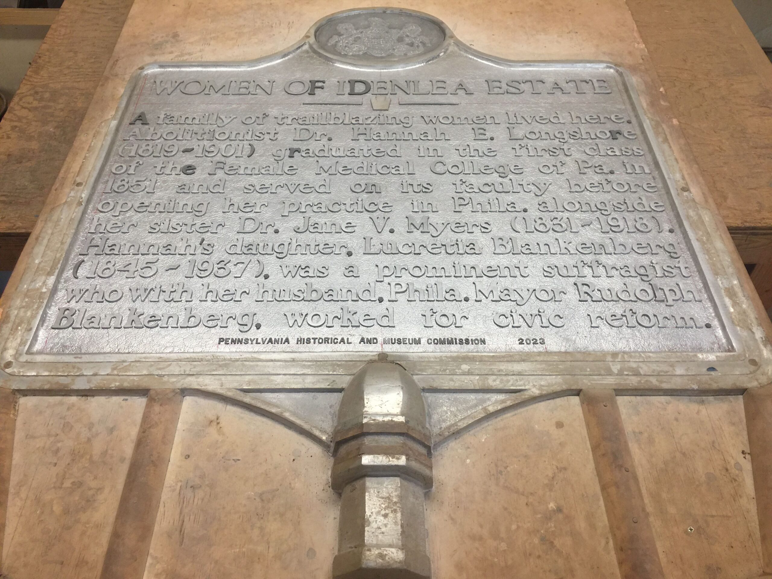 Unpainted metal sign with words and state seal of Pennsylvania.