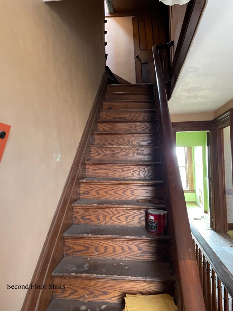 Wood staircase with hallway and open doors to right.