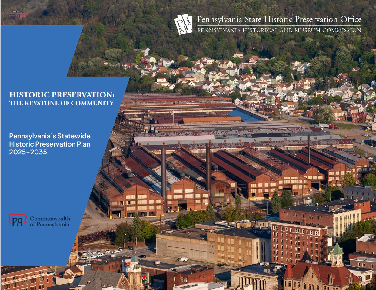 Aerial image of downtown and factory with a large blue keystone at left side.