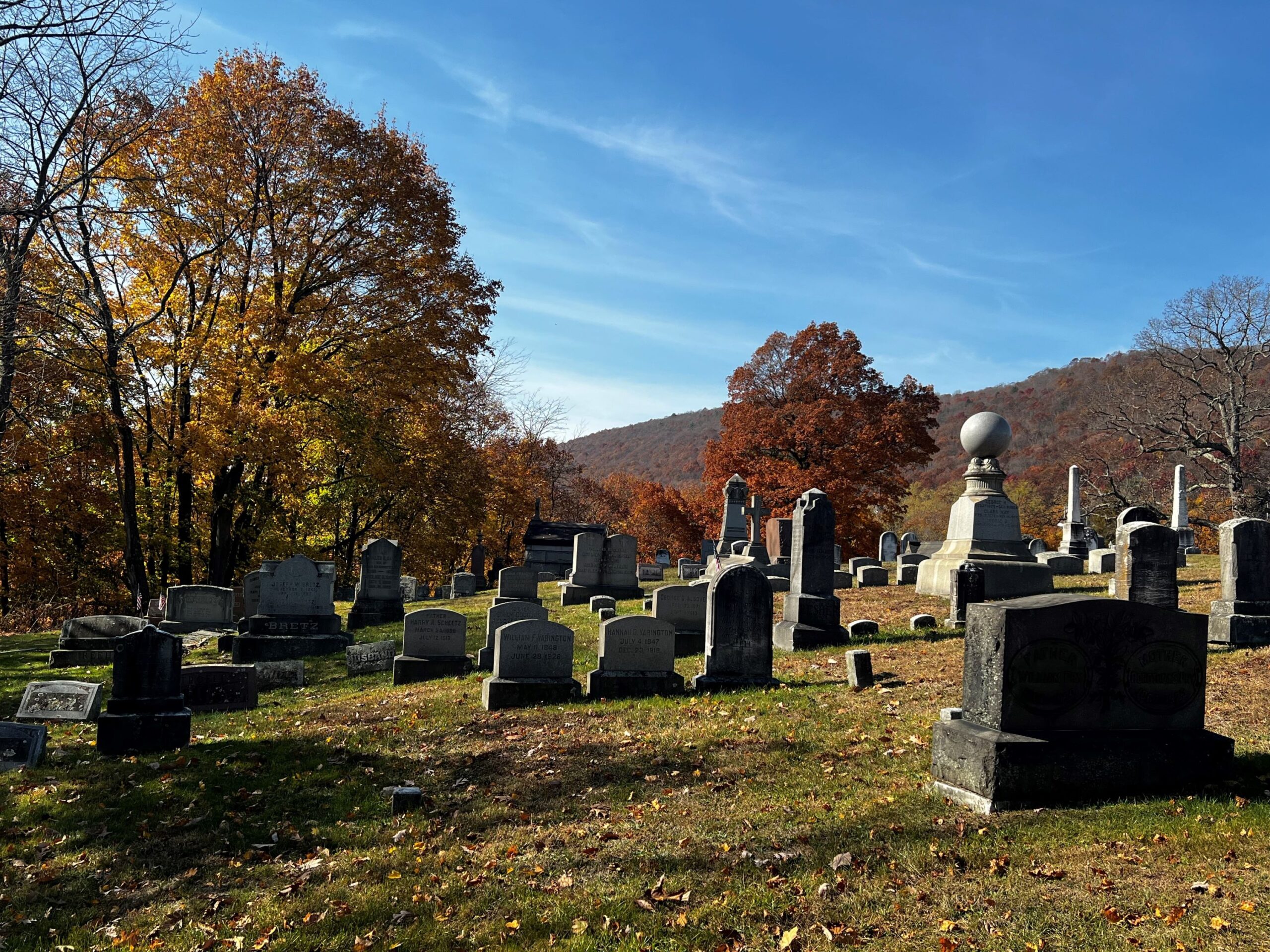 Looking across grassy area at many masonry grave markers.