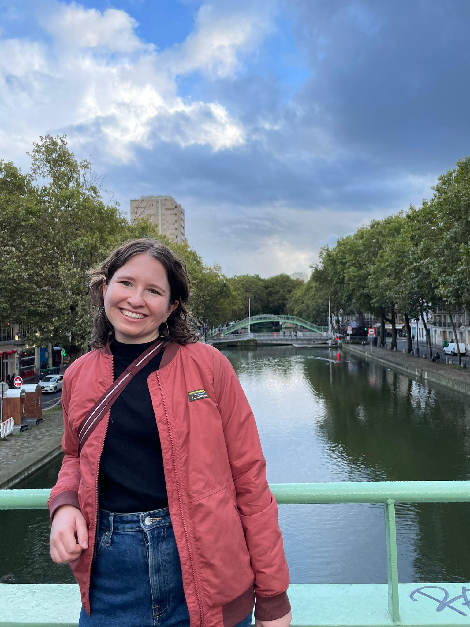 Woman standing on a bridge over water.