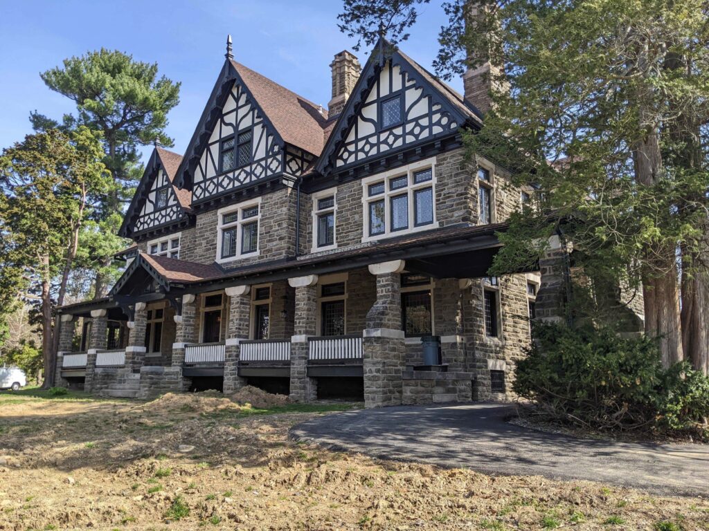 Large three story stone building with many rooflines and decorative features.