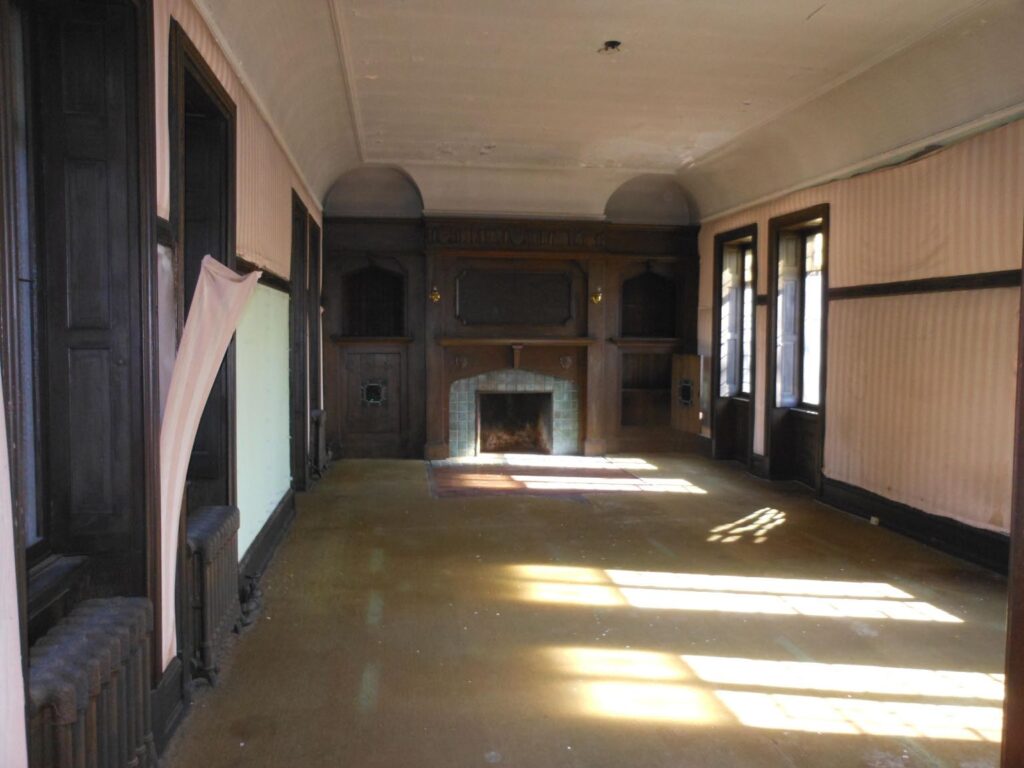 Large room with sunlight coming through windows on right wall.