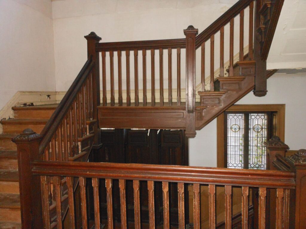 Staircase with wood railing at different levels.