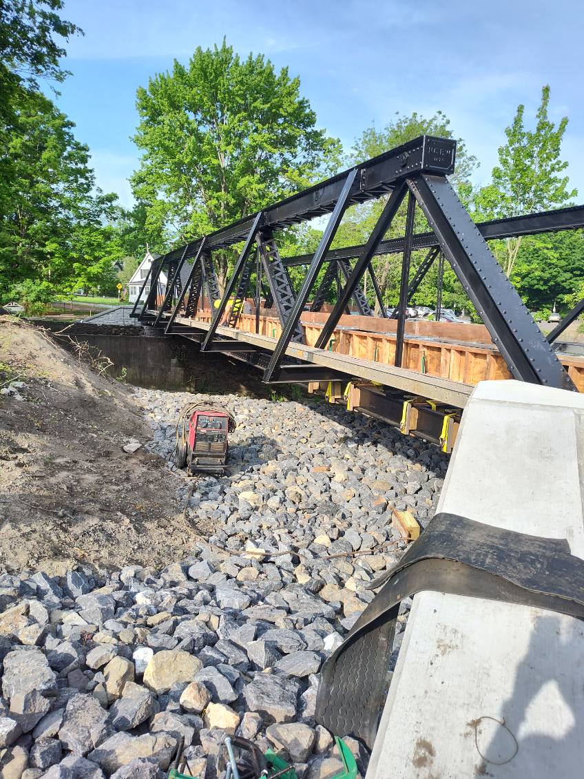 Metal bridge over stone in a ditch.