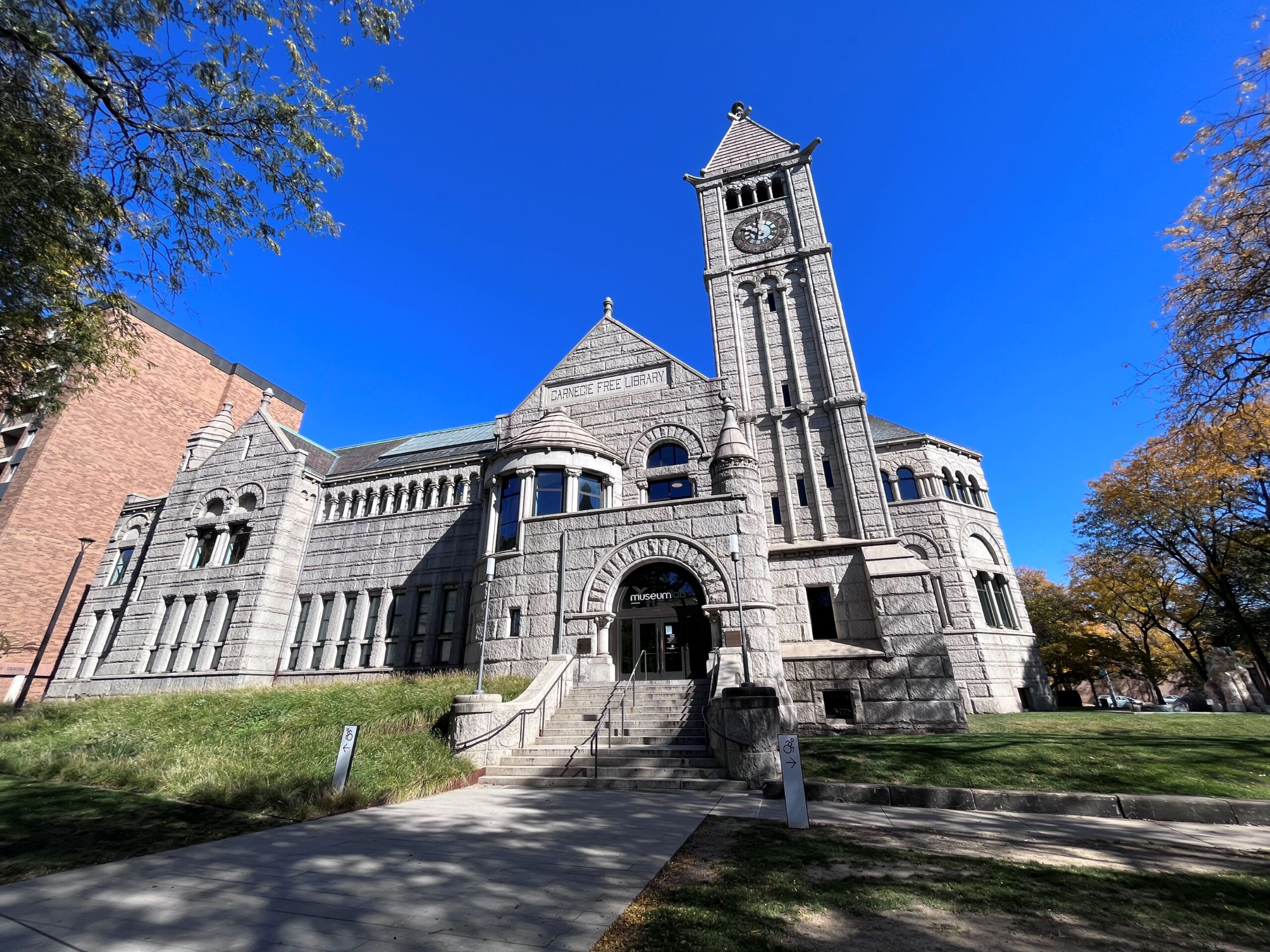 Large stone building with a tall clock tower at one end.