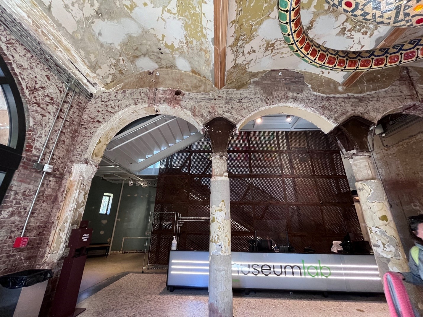 Interior space with columns and brick walls and arched vault ceiling.