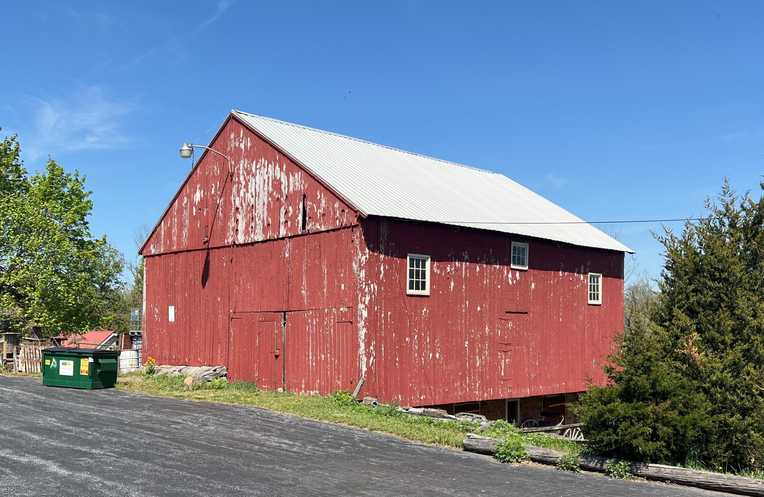 Two story barn painted red with a metal gable roof.