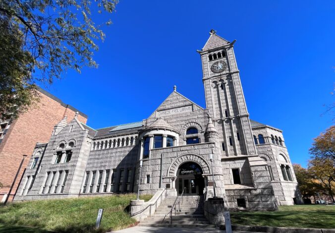 Large stone building with a tall clock tower at one end.