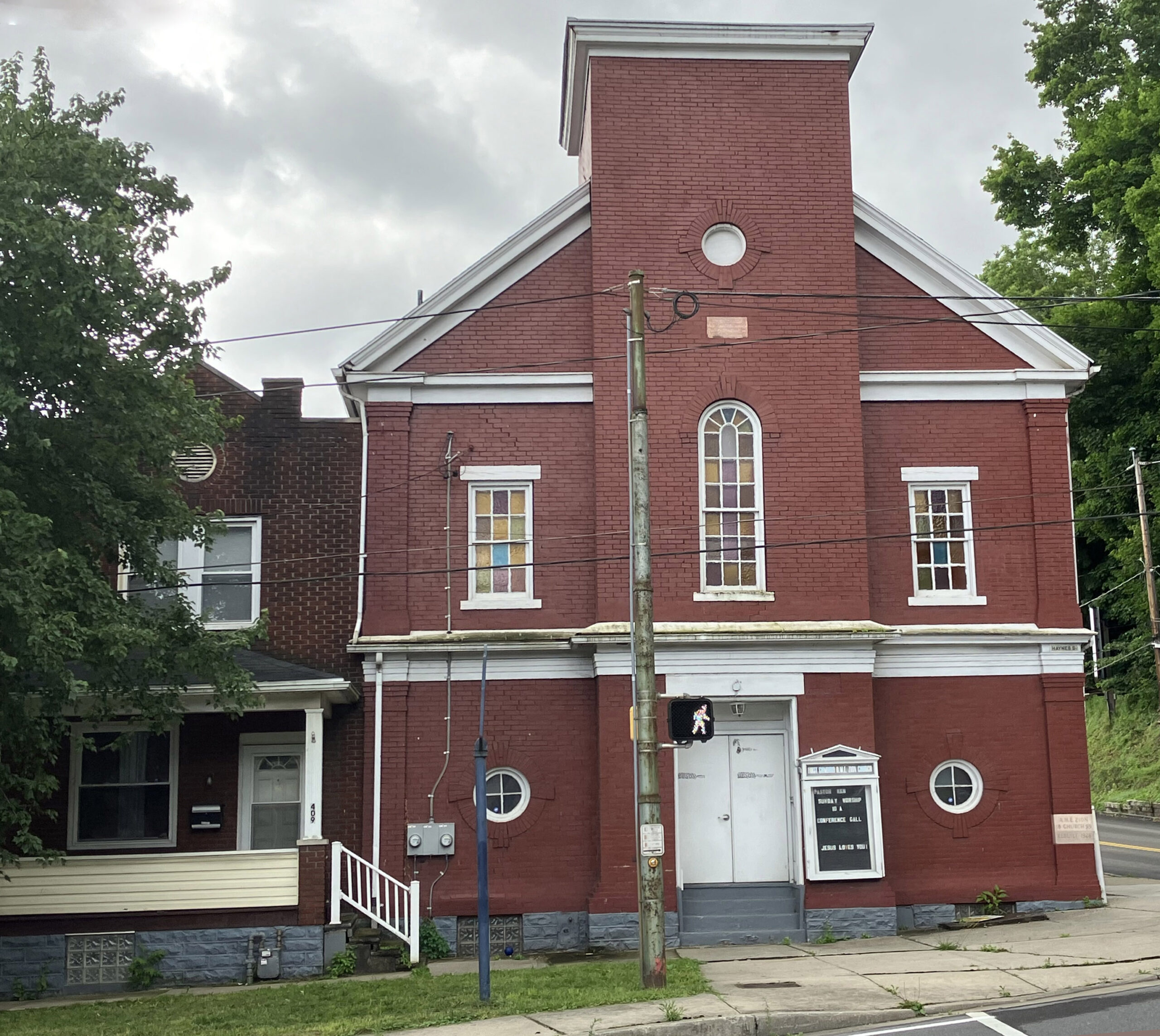 Two story brick church with tall center tower.