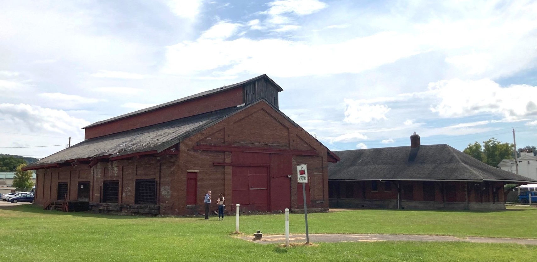 Two large rectangular brick buildings parallel to each other on a grassy lot.