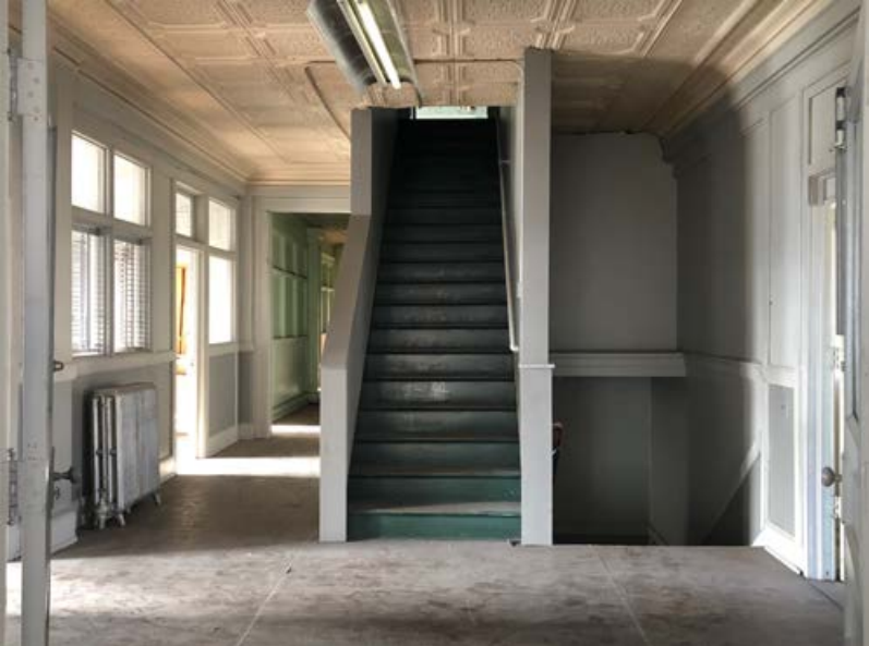 Corridor with staircase and interior office partitions.