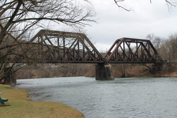 Looking at two large sections of metal bridge over water.