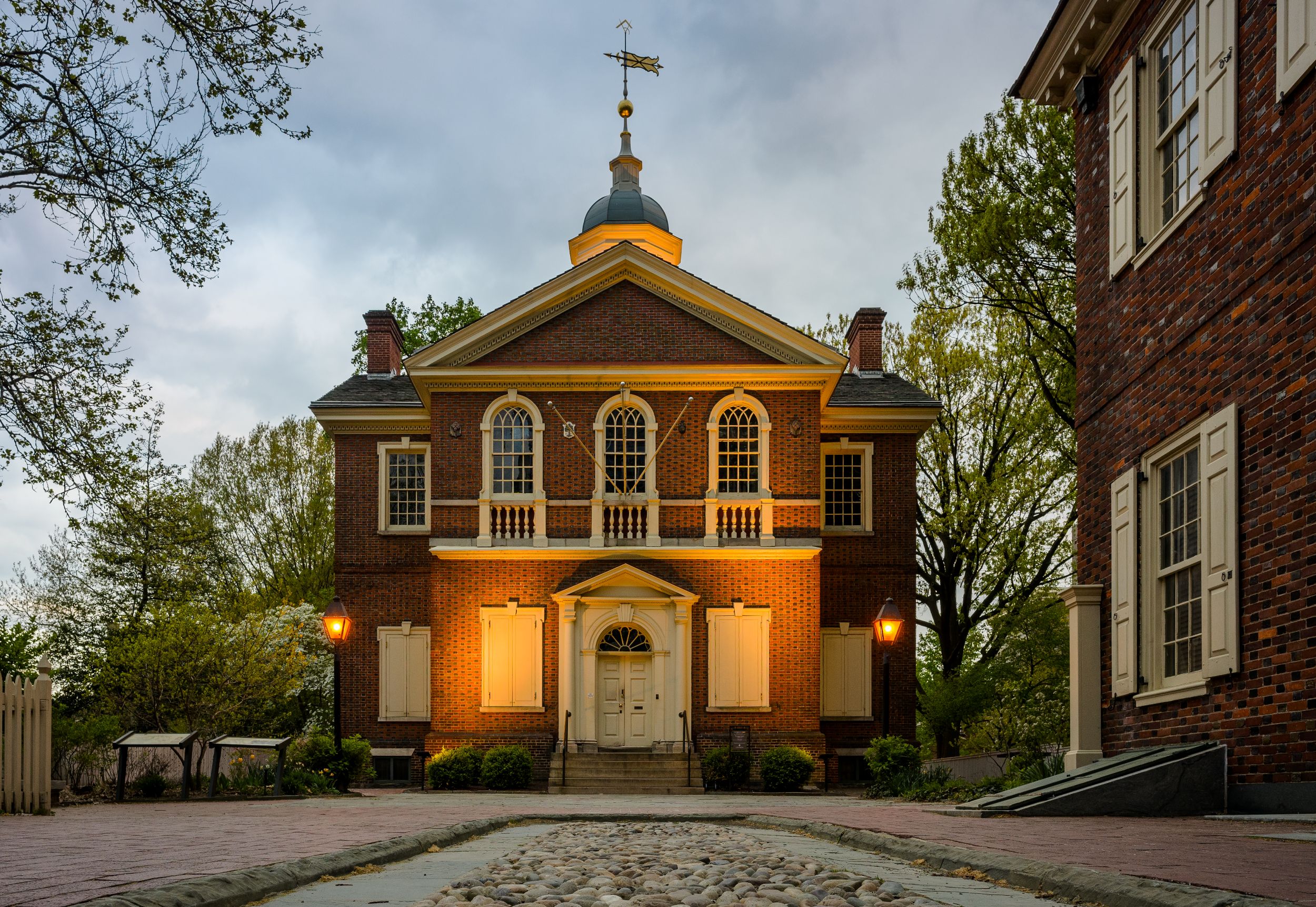Large two-story brick building with wood details and cupola on the roof.