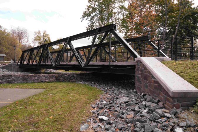 Metal bridge over rocks and grass.