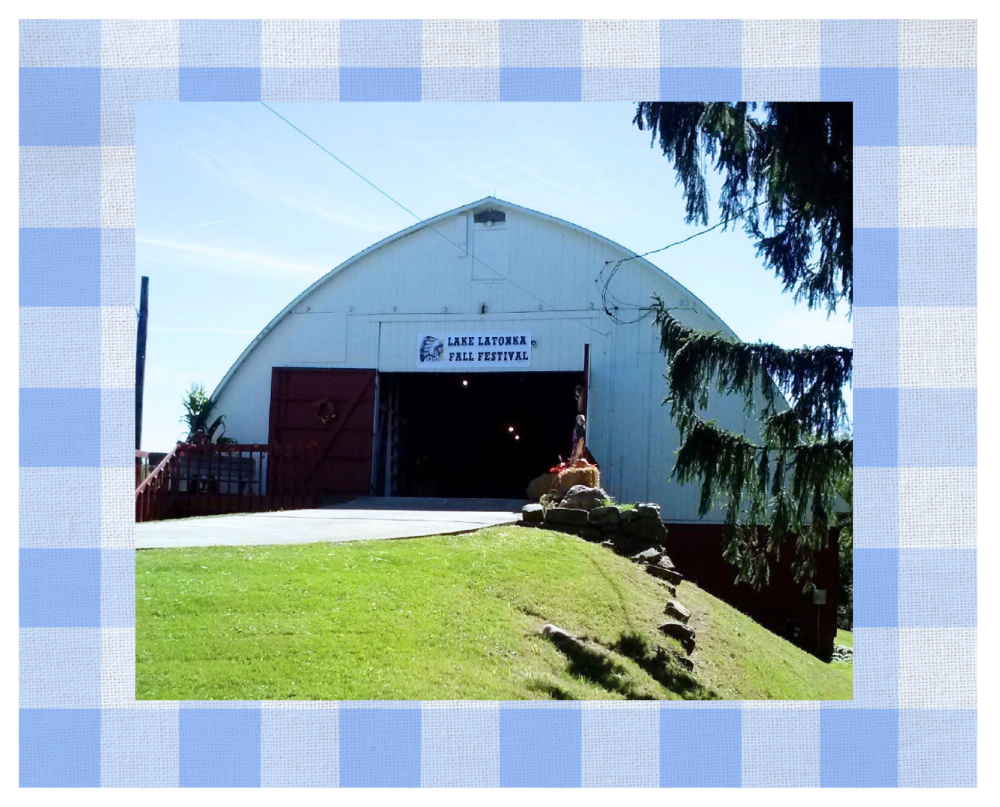 Large white barn with a paved road running into the center opening.