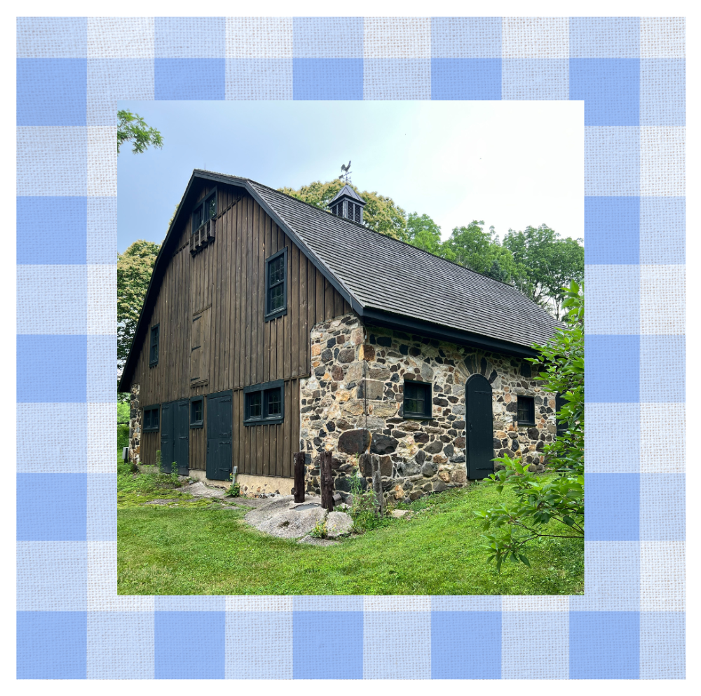 Small stone and wood barn set in a hillside.