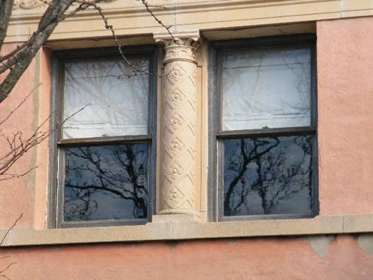 Two one-over-one wood windows separate by decorative column.